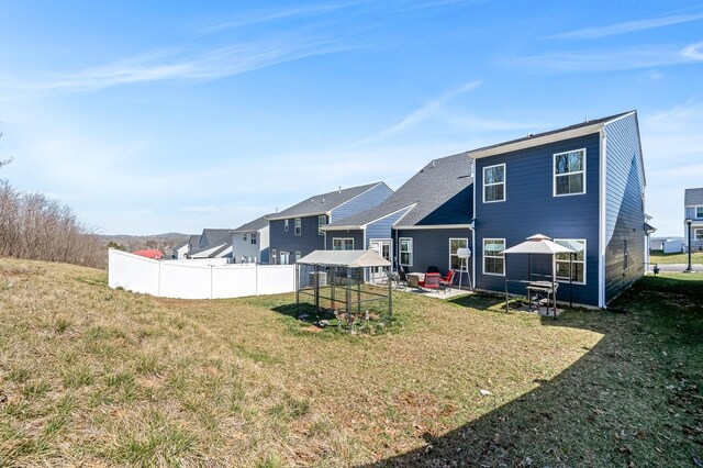 back of property featuring a lawn, a patio area, and fence