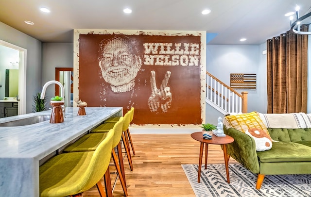 sitting room featuring light wood-style floors, recessed lighting, baseboards, and stairs