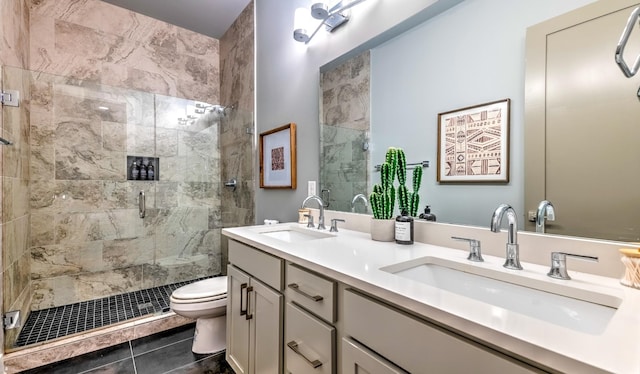 bathroom with toilet, a stall shower, double vanity, and a sink