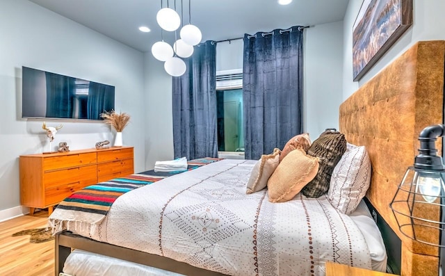 bedroom featuring baseboards, wood finished floors, and recessed lighting