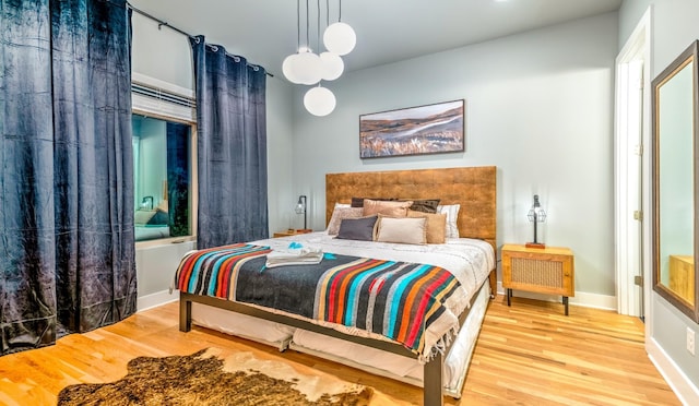 bedroom featuring baseboards and wood finished floors