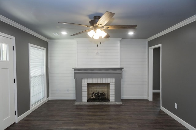 unfurnished living room featuring a brick fireplace, crown molding, baseboards, and wood finished floors