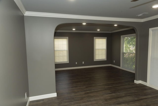 spare room featuring dark wood-type flooring, recessed lighting, crown molding, and baseboards