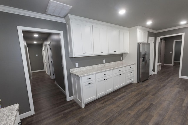 kitchen featuring white cabinetry, visible vents, stainless steel refrigerator with ice dispenser, and ornamental molding