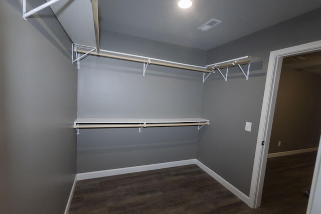 spacious closet with dark wood-style floors and visible vents