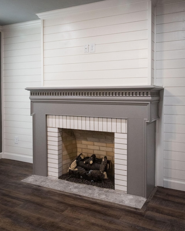 room details with wood walls, a fireplace, wood finished floors, and baseboards