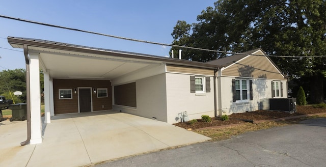 view of front of property featuring a carport, cooling unit, and brick siding