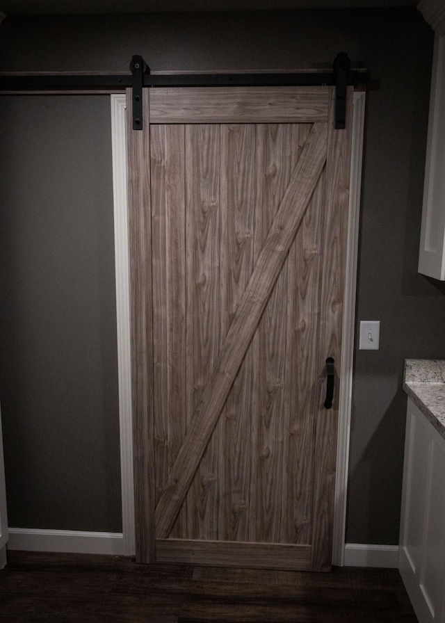 interior details with baseboards and a barn door