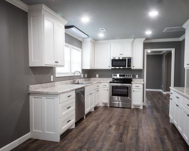 kitchen featuring dark wood-style flooring, stainless steel appliances, visible vents, white cabinetry, and a sink