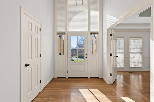 foyer entrance featuring baseboards and wood finished floors