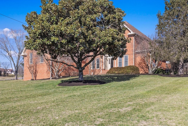 view of front of property with brick siding and a front lawn