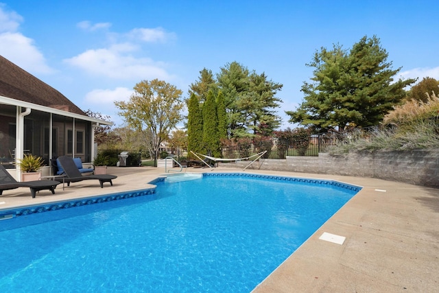 view of pool featuring a fenced in pool, a sunroom, a patio area, and fence