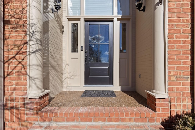 view of exterior entry with brick siding