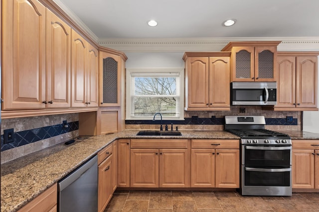 kitchen featuring stone counters, stainless steel appliances, a sink, decorative backsplash, and glass insert cabinets