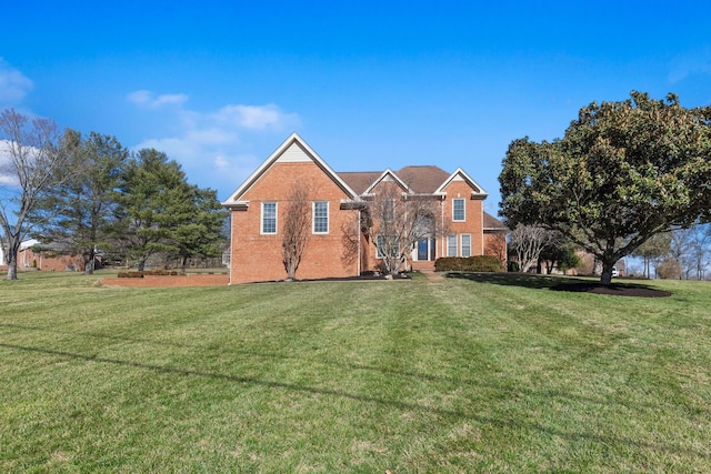 view of front facade with brick siding and a front yard