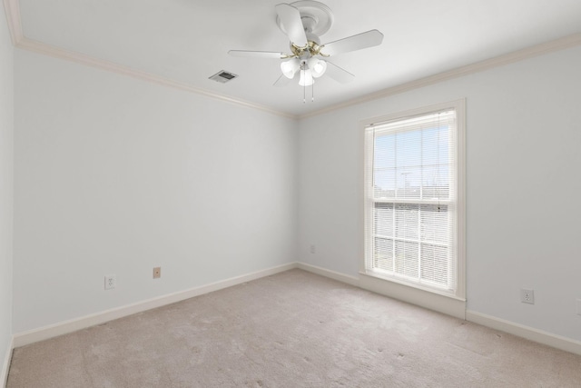 empty room featuring baseboards, carpet, visible vents, and crown molding