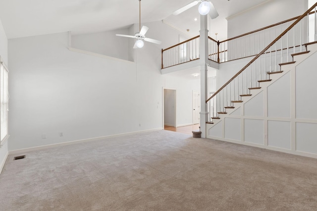 unfurnished living room featuring visible vents, ceiling fan, carpet, stairs, and ornate columns