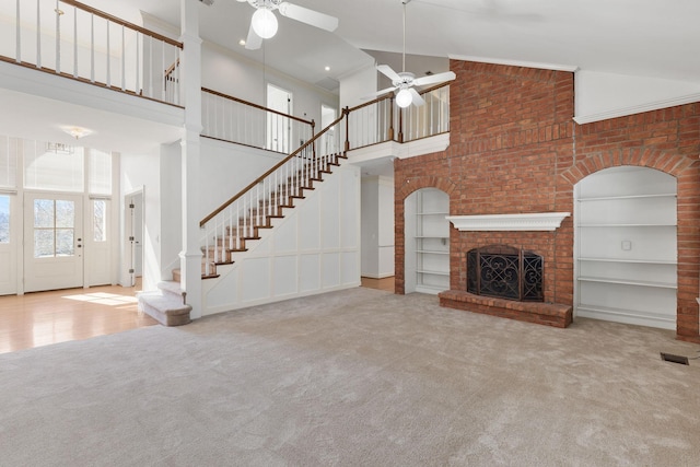 unfurnished living room featuring a fireplace, carpet flooring, and a ceiling fan