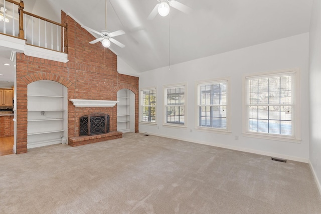 unfurnished living room with built in features, ceiling fan, carpet flooring, a brick fireplace, and high vaulted ceiling