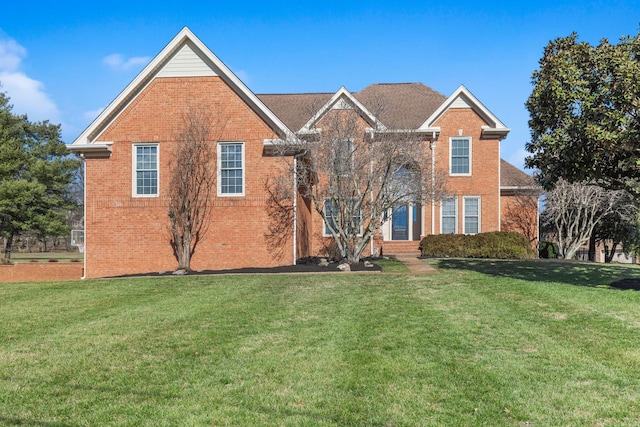 view of front of property with a front lawn and brick siding