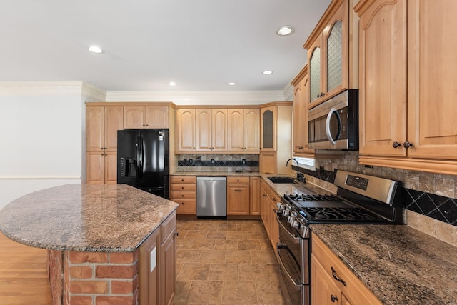 kitchen featuring dark stone counters, stainless steel appliances, a sink, and glass insert cabinets