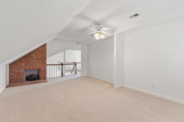 unfurnished living room featuring lofted ceiling, baseboards, visible vents, and light colored carpet