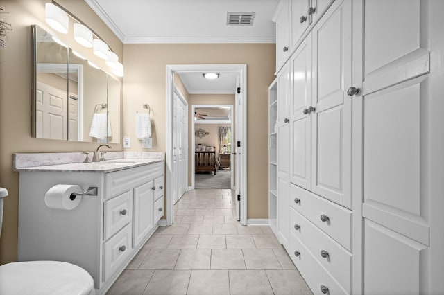 bathroom featuring visible vents, toilet, ornamental molding, vanity, and tile patterned flooring