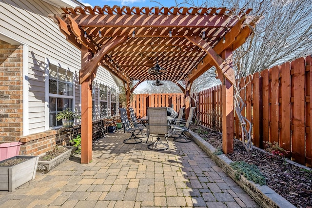 view of patio with a fenced backyard, a ceiling fan, outdoor dining area, and a pergola