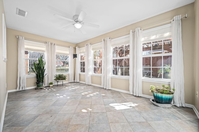 unfurnished sunroom featuring visible vents and a ceiling fan