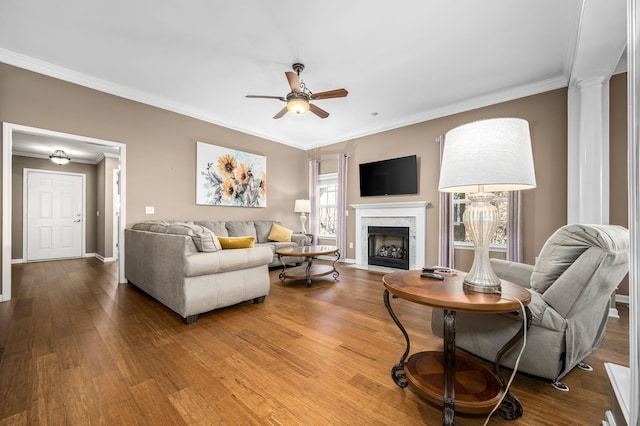 living room with ornamental molding, wood finished floors, and a ceiling fan