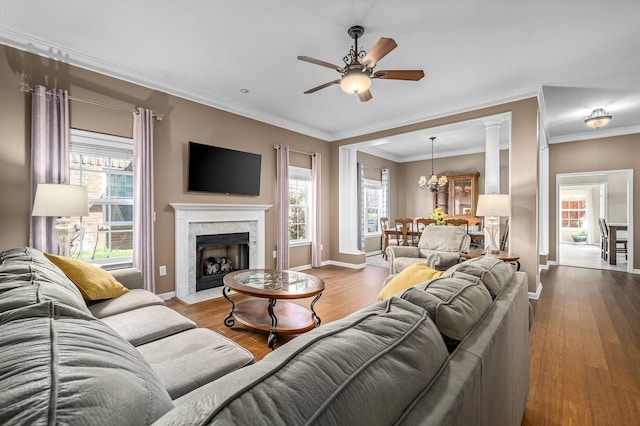 living area with ornamental molding, baseboards, and wood finished floors