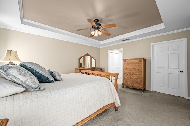 bedroom with carpet, crown molding, a raised ceiling, visible vents, and a ceiling fan