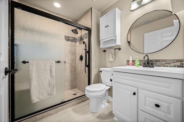 bathroom with visible vents, decorative backsplash, toilet, vanity, and a shower stall