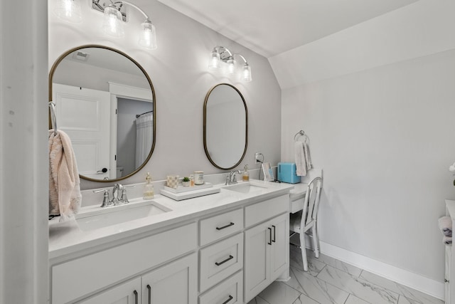 bathroom with double vanity, marble finish floor, baseboards, and a sink