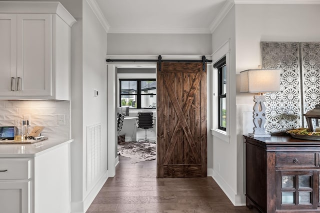 interior space featuring ornamental molding, visible vents, hardwood / wood-style floors, and a barn door