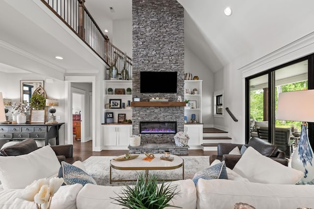 living area with stairway, a stone fireplace, a high ceiling, and wood finished floors