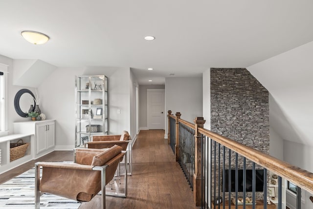 interior space with an upstairs landing, baseboards, wood finished floors, and recessed lighting