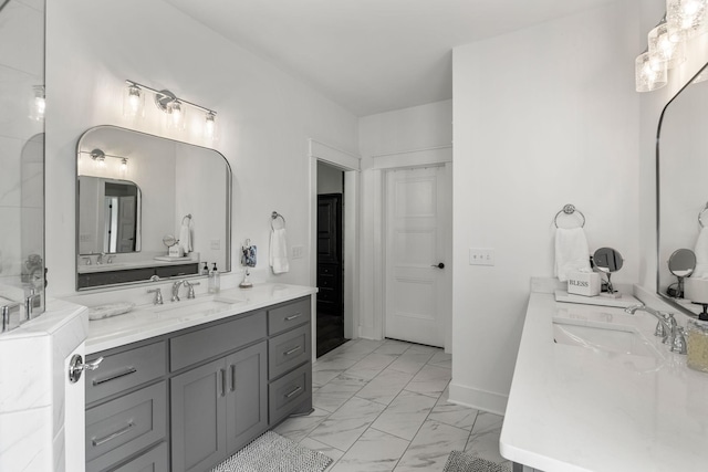 bathroom with marble finish floor, two vanities, a sink, and baseboards