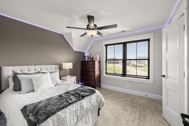 bedroom with lofted ceiling, a ceiling fan, visible vents, baseboards, and carpet