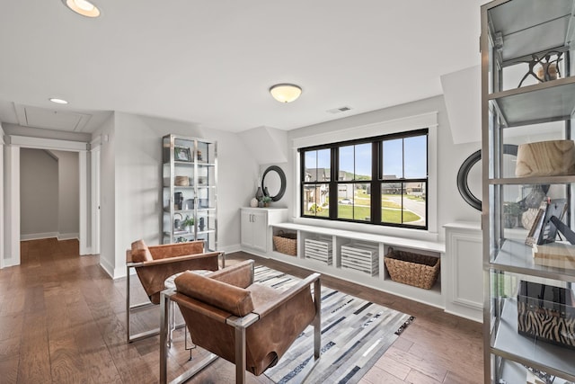 living area featuring visible vents, hardwood / wood-style flooring, and baseboards