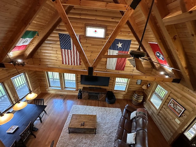 unfurnished living room featuring beam ceiling, log walls, wood ceiling, high vaulted ceiling, and hardwood / wood-style flooring