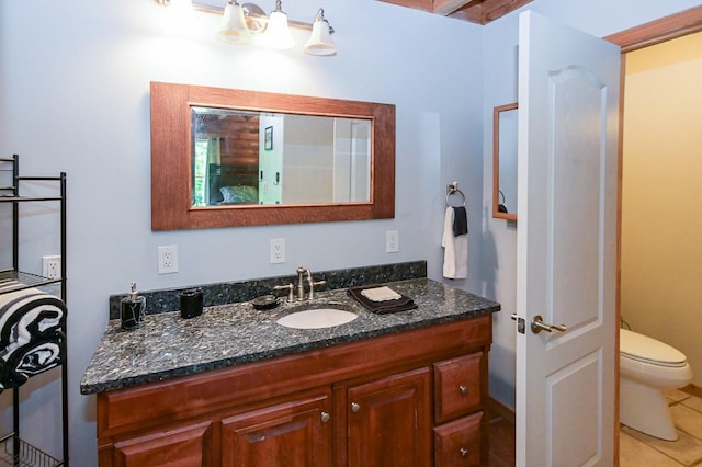 bathroom with toilet, vanity, and tile patterned floors