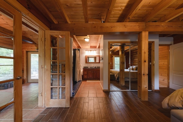 interior space with plenty of natural light, dark wood-style flooring, beamed ceiling, and wooden ceiling