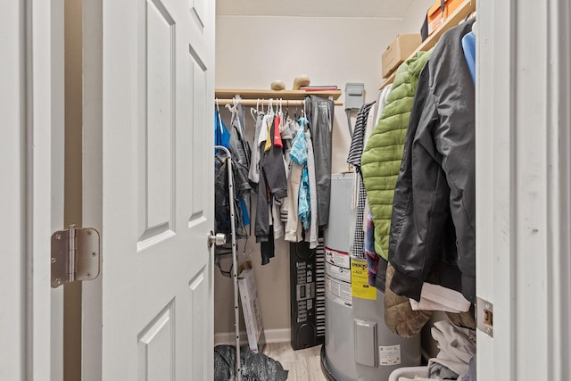 spacious closet with water heater and wood finished floors