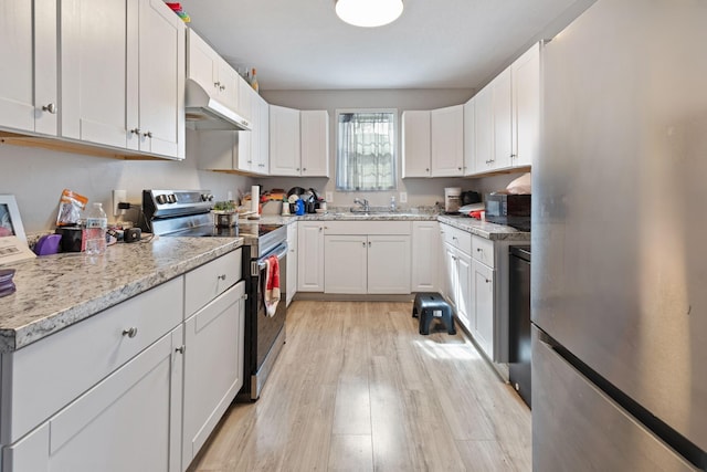 kitchen with stainless steel appliances, a sink, white cabinets, and under cabinet range hood