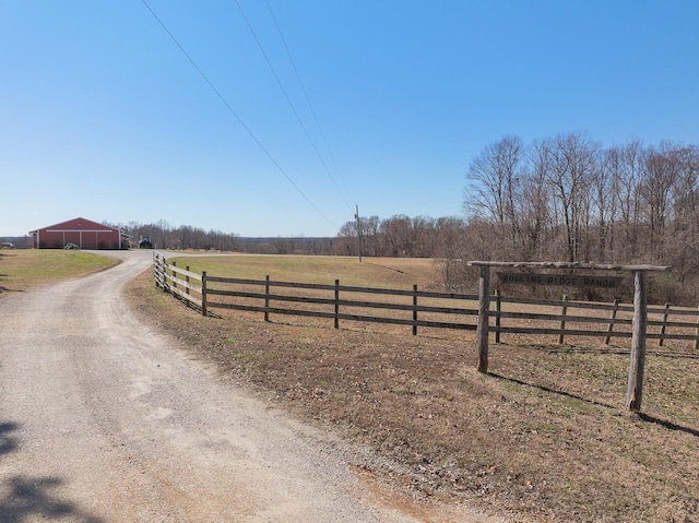 view of street featuring an outbuilding, a rural view, and dirt driveway