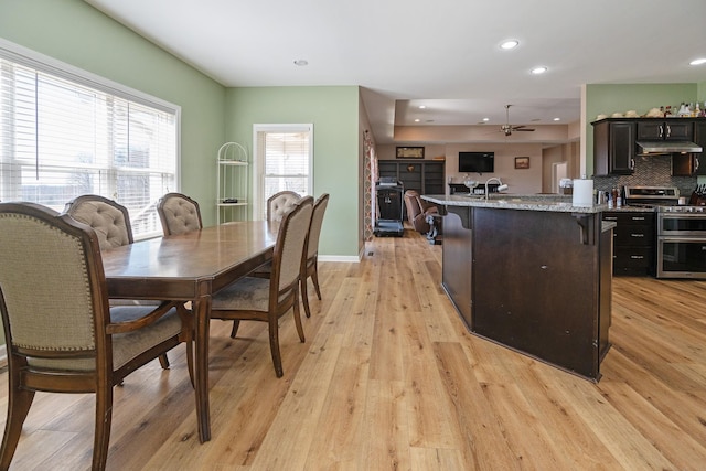 dining room featuring recessed lighting, light wood-type flooring, a ceiling fan, and baseboards