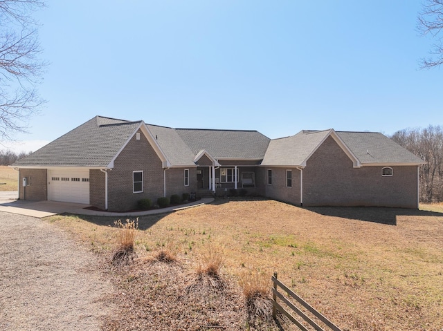 ranch-style home featuring a garage, driveway, and brick siding