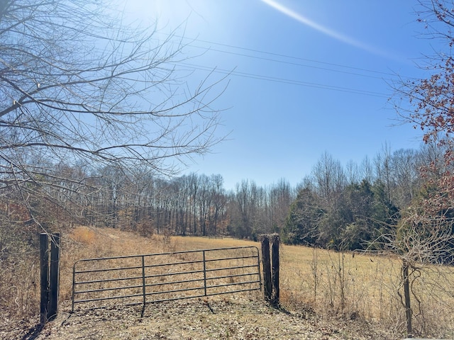 view of gate featuring fence and a wooded view