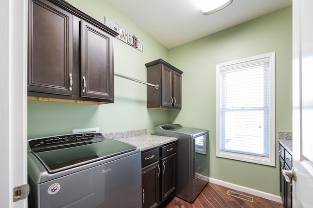 laundry room featuring separate washer and dryer, dark wood-style flooring, visible vents, baseboards, and cabinet space